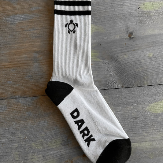 White sock with black accents and 'DARK' text on a wooden surface